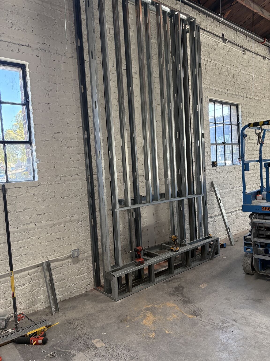 Tall steel framing against the painted brick wall at Pepper Place